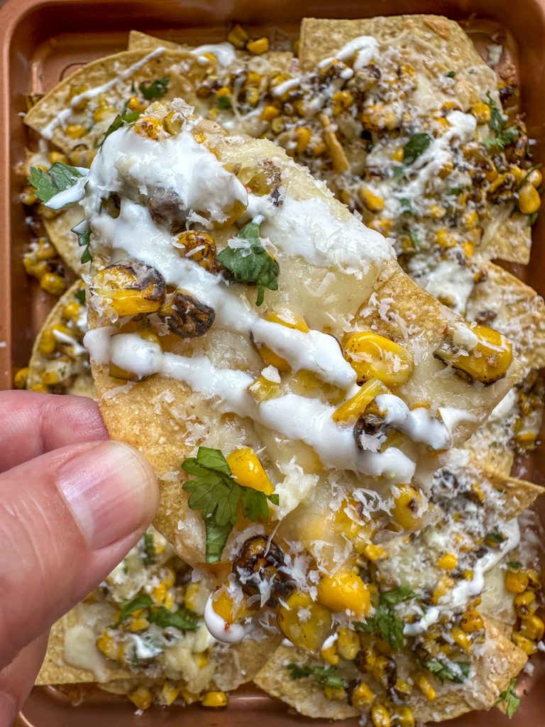 Nachos topped with mexican street corn, monterrey jack cheese, and cotija cheese