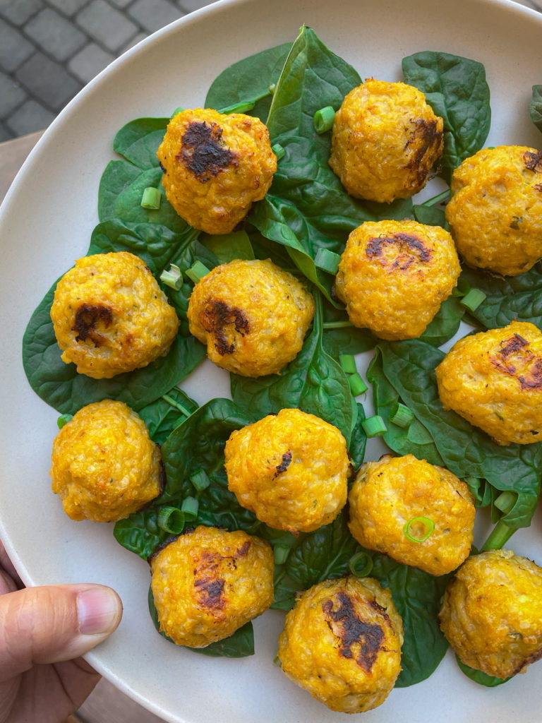 chicken pumpkin meatballs on a bed of fresh spinach