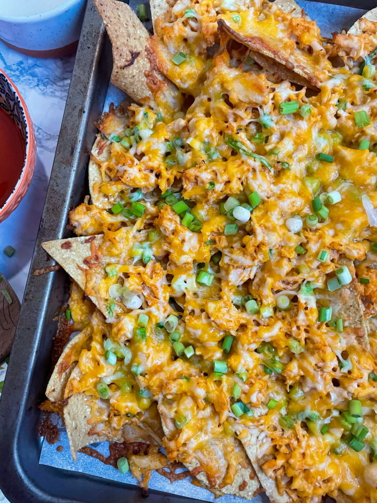 Buffalo Chicken Nachos with buffalo chicken, ranch dressing, and cheese