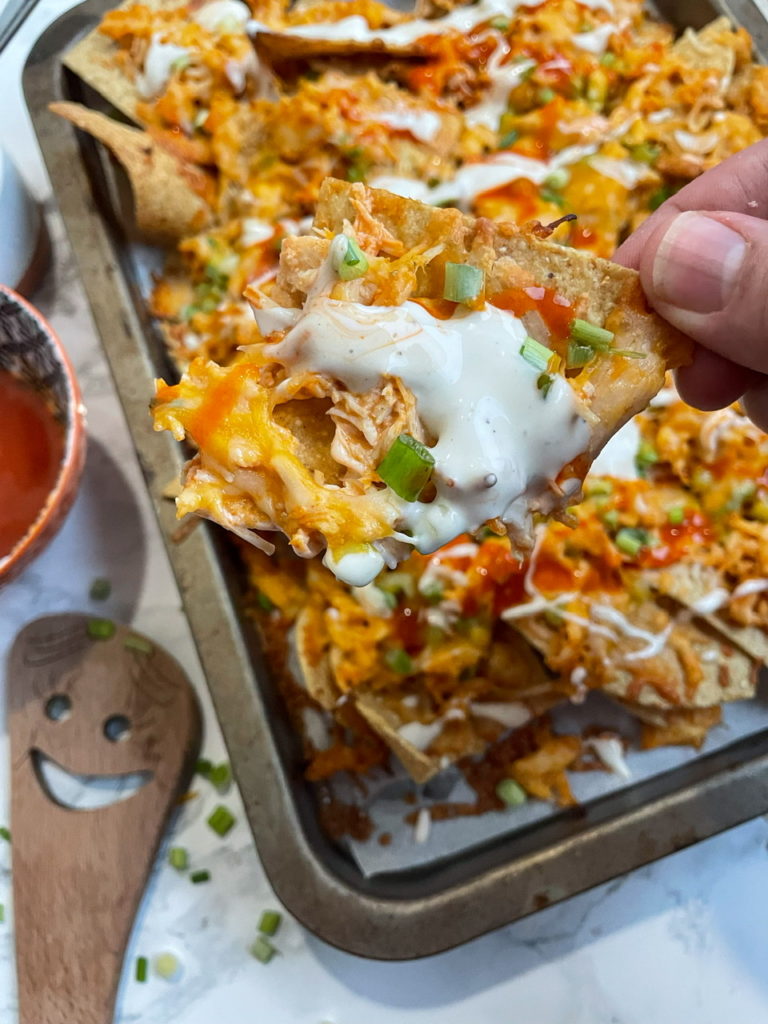 Buffalo Chicken Nachos with buffalo chicken, ranch dressing, and cheese