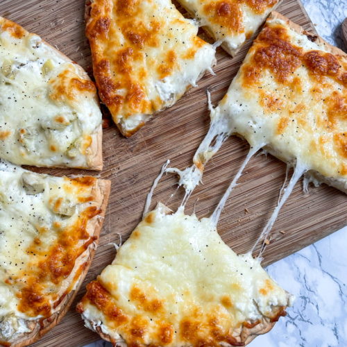 Ricotta Pizza is a white pizza with ricotta cheese, mozzarella cheese, and pecorino cheese on flatbread.