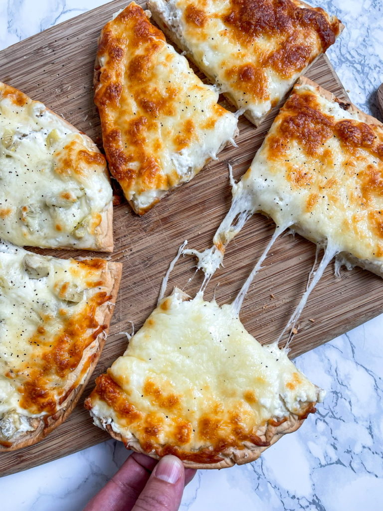 Ricotta Pizza is a white pizza with ricotta cheese, mozzarella cheese, and pecorino cheese on flatbread.