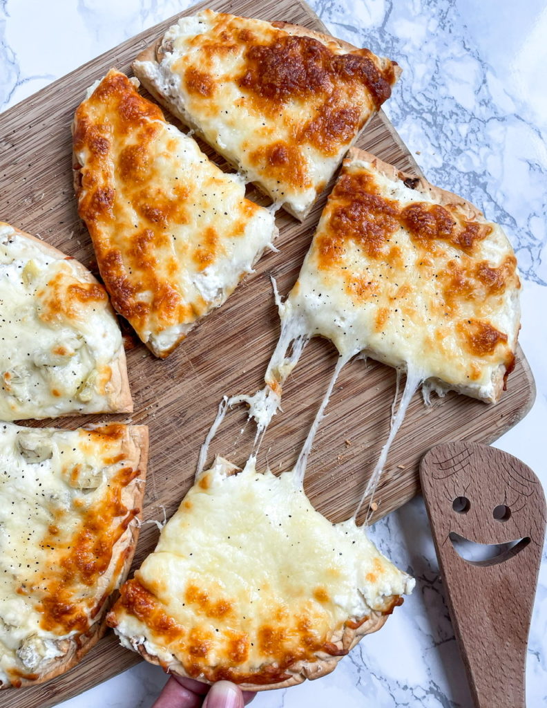 Ricotta Pizza is a white pizza with ricotta cheese, mozzarella cheese, and pecorino cheese on flatbread. 