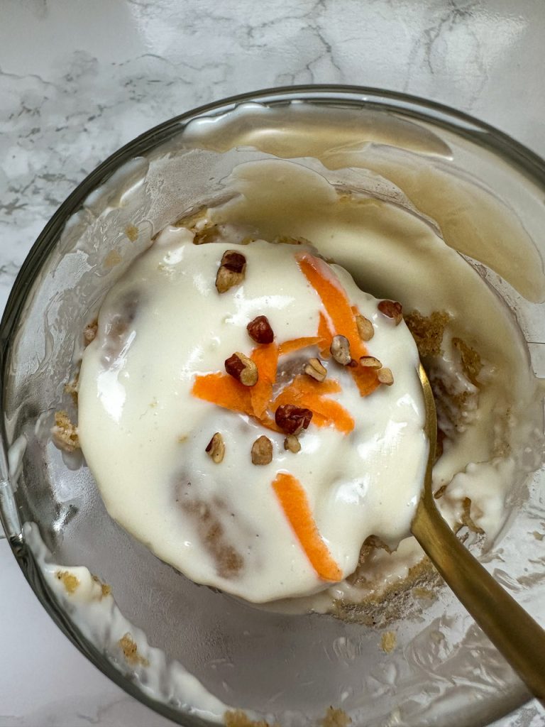 Carrot Cake cooked in a mug with cream cheese frosting on top