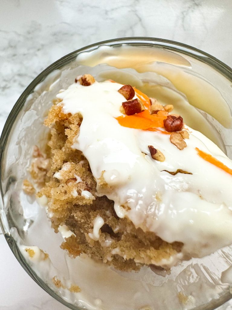 Carrot Cake made in a mug topped with cream cheese frosting