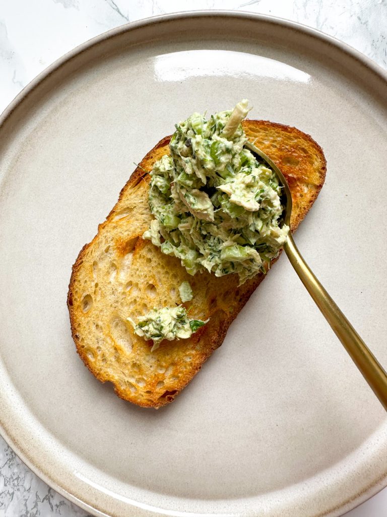 Green Goddess Tuna Salad being spread onto toasty bread