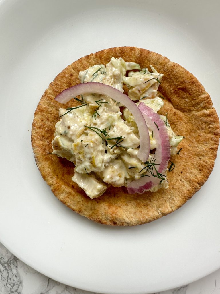 Tzatziki Chicken Salad on a mini pita bread topped with red onion