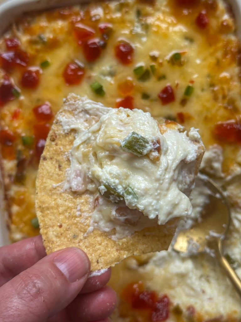 Jalapeño popper dip with jalapeños, garlic, cream cheese, and bacon. Topped with pepper jelly and served with tortilla chips