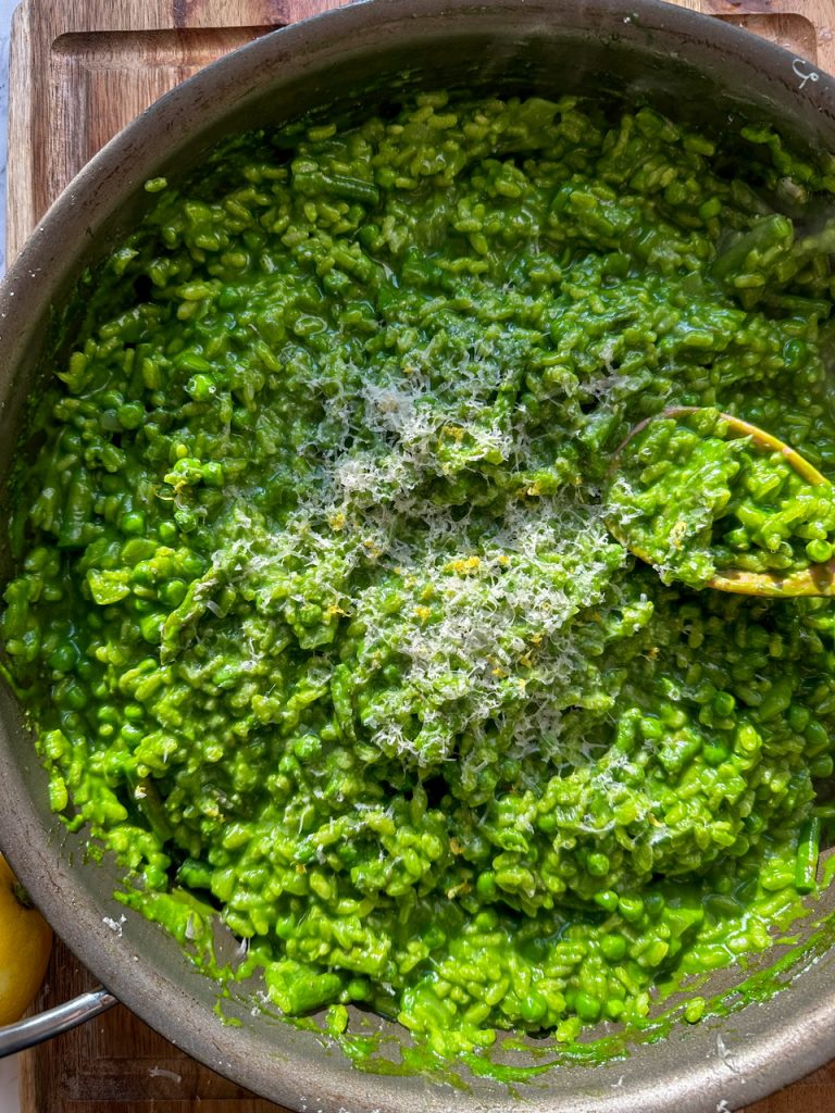 Risotto Verde (Green Risotto) made with spinach, peas, and asparagus. Topped with lemon zest and parmesan cheese.