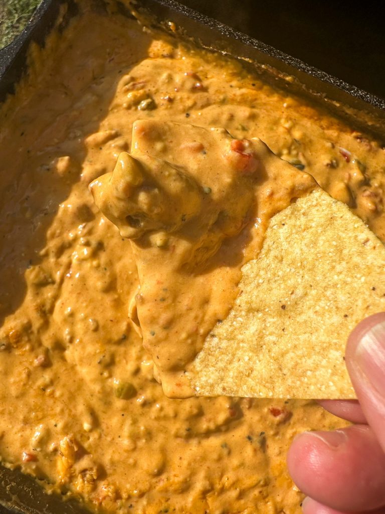 tortilla dip being dipped into queso