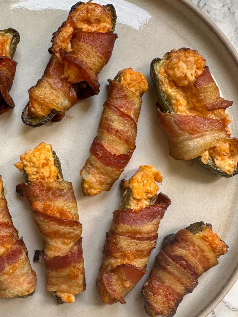 smoked jalapeno poppers stuffed with cream cheese and cheddar cheese, and then wrapped in crispy bacon