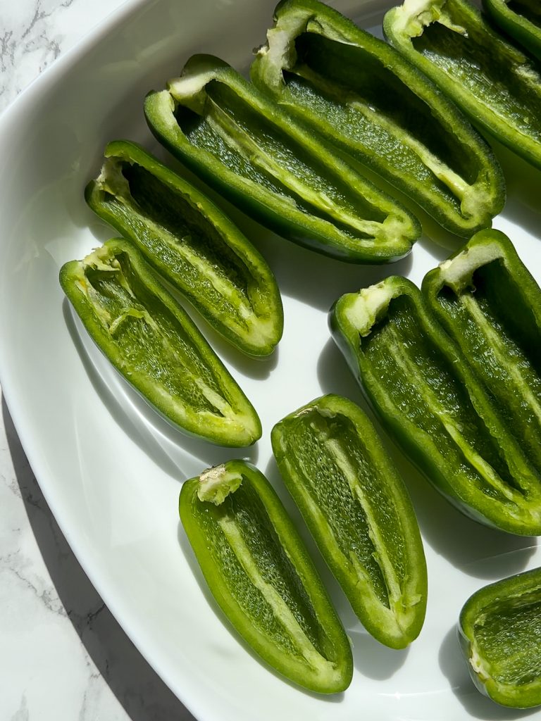 jalapenos sliced in half with the seeds removed