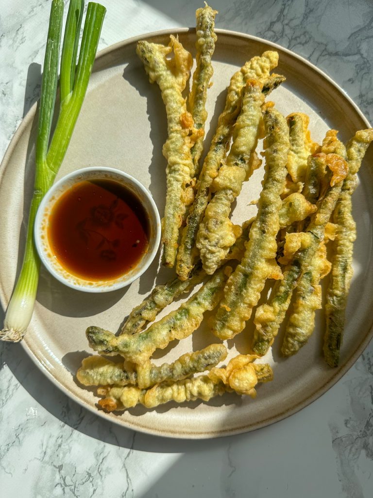 Asparagus Tempura served on a plate alongside tempura dipping sauce