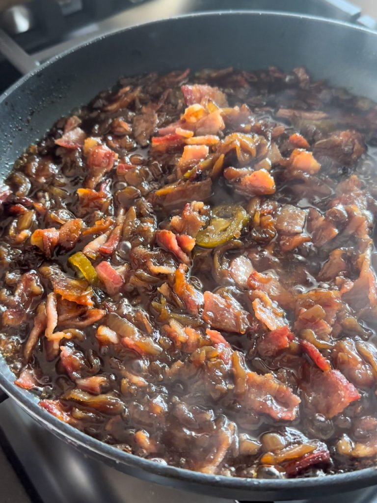 Making Bacon Jam with bacon, onion, garlic, sugar, jalapeños, and vinegar