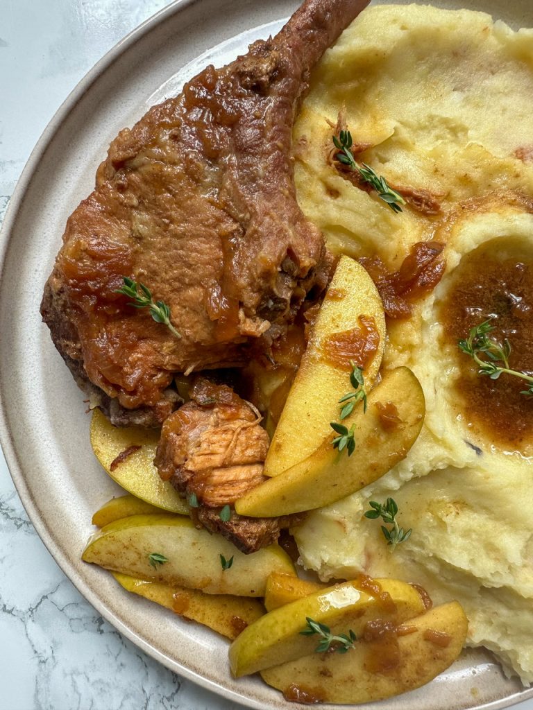 Pork chops cooked with caramelized onions and apples in the slow cooker