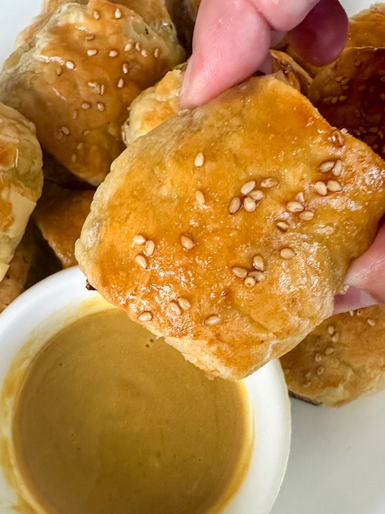 Pork and Apple Sausage Rolls being dipped into a Honey Dijon dipping sauce