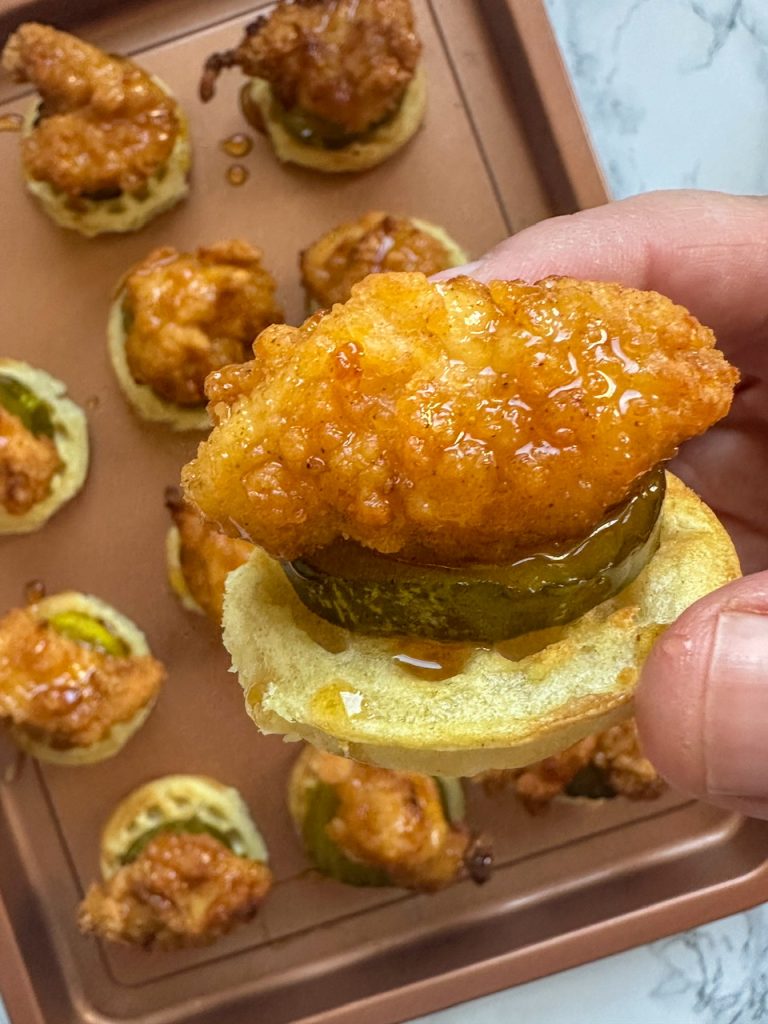 close up of a chicken and waffle bite made with frozen chicken, frozen waffles, pickle slices, and hot honey.