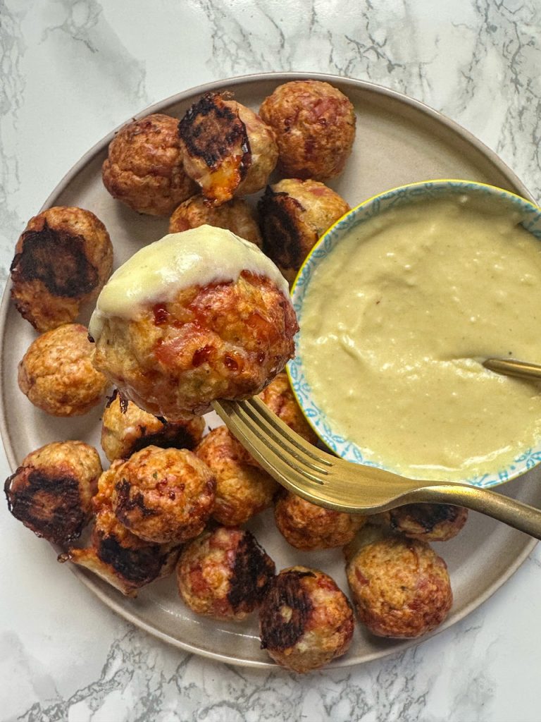 chicken meatballs stuffed with ham and swiss cheese served with a creamy dijon sauce