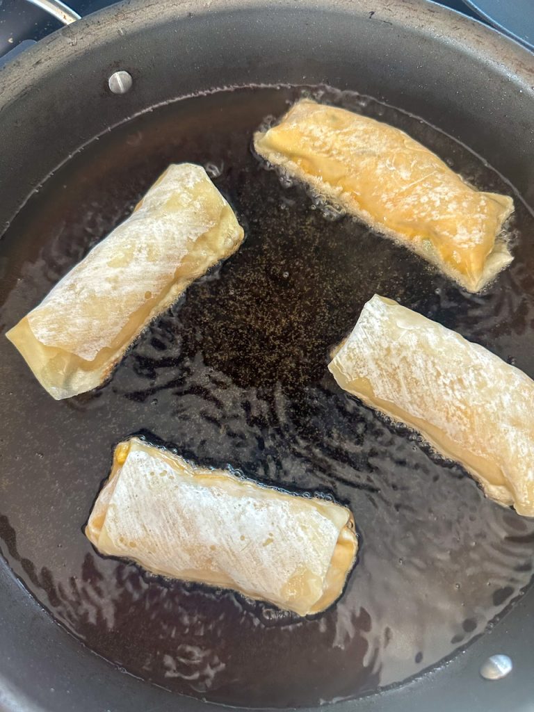 buffalo chicken egg rolls frying in oil