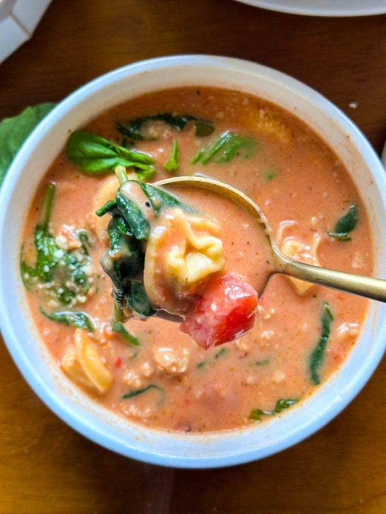 Creamy tortellini in soup with spinach and sausage