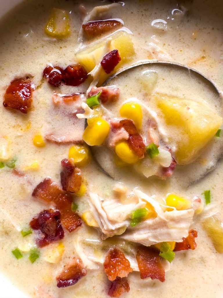 Slow cooker chicken and corn chowder with shredded chicken, corn, potatoes, and bacon